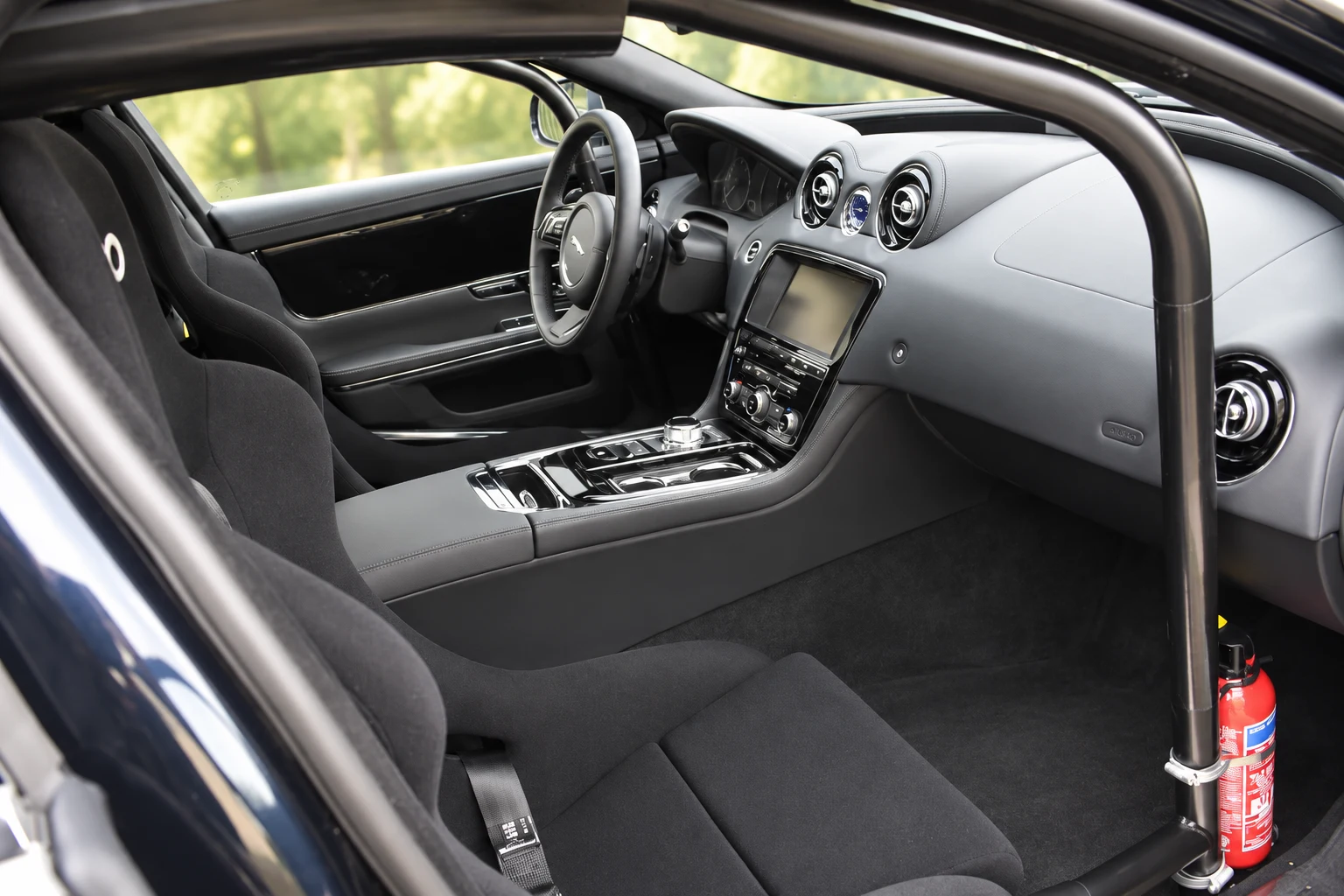 The front racing seat and cage beside the standard XJ dashboard